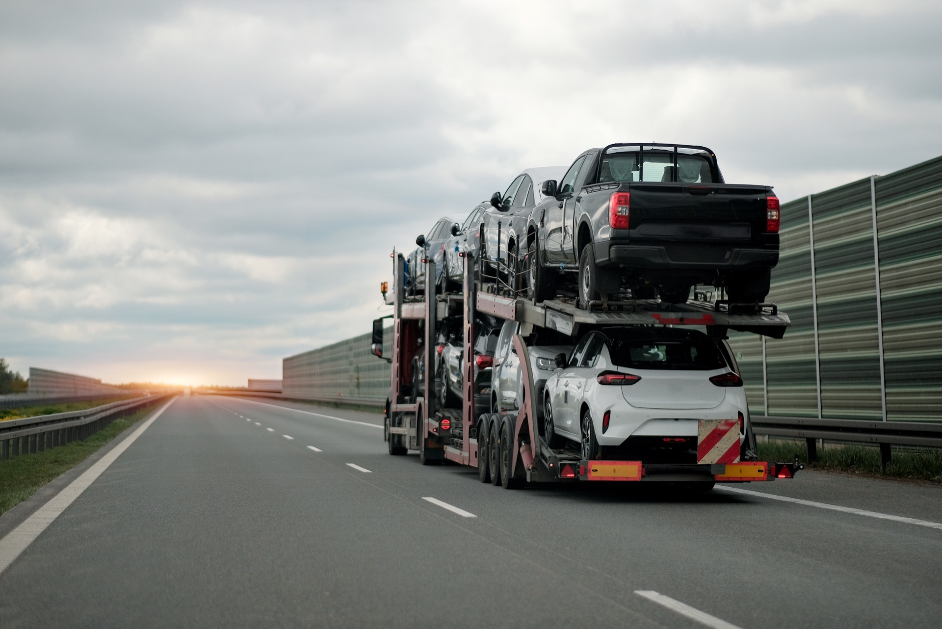 Autotransporter mit mehreren Fahrzeugen auf einer Autobahn